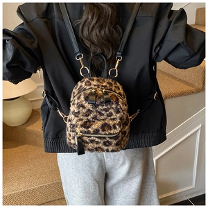 Detailed back view of a mini leopard print plush backpack with black faux leather straps