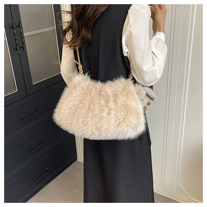 Détail d'un sac à bandoulière en fausse fourrure beige avec peluche douce et charme lapin