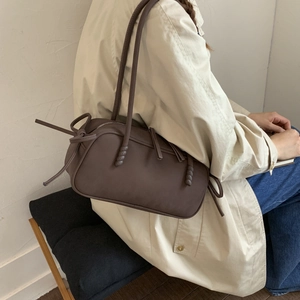 Brown matte leather shoulder bag styled with a beige trench coat for an autumn commute look
