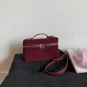 Detailansicht der burgunderroten Box-Tasche aus Mattleder mit silbernen Reißverschlüssen