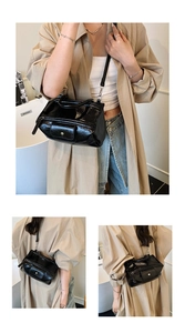 Detail of glossy black oil wax leather texture and silver buckle on large tote bag