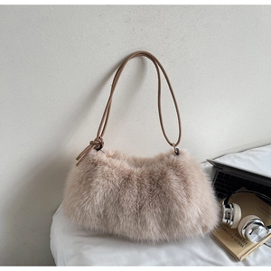 Détails de la texture en fausse fourrure et de la bandoulière du sac abricot