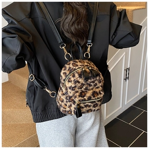 Detailed close-up of a stylish mini leopard print backpack with gold hardware and leather straps