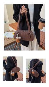 Detail view of dark brown suede shoulder bag featuring brand logo and teddy bear charm