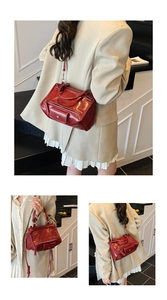 Detail view of deep red glossy leather handbag with vintage hardware and strap