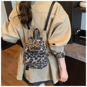 Detail view of mini leopard print plush backpack with black leather straps and gold zippers