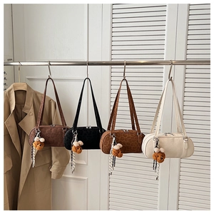 Detailed row of vintage faux suede cylindrical bags in four colors with bear charms