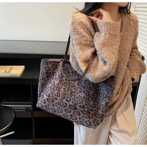 Detail shot of leopard print tote bag with brown leather straps and thick canvas texture