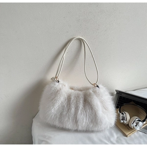 Sac à épaule en fausse fourrure blanche avec ordinateur et casque sur un bureau