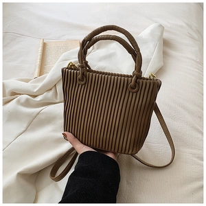 Close-up of brown pleated bucket bag showing premium PU leather texture and gold hardware