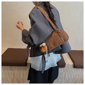 Detail of vintage leopard print suede underarm bag with cute plush bear and bow charm