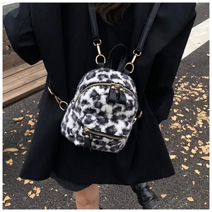 Detail of mini black and white leopard print backpack in soft plush with gold zippers