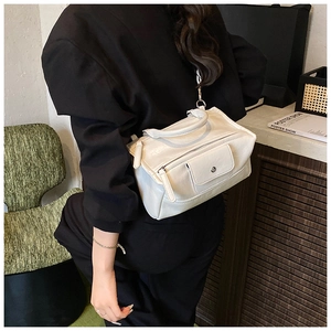 French style white tote bag shown on a model with a black crossbody strap and leather texture