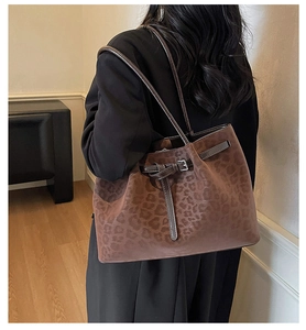 Detail shot of vintage brown leopard print tote bag with leather strap and metal buckle
