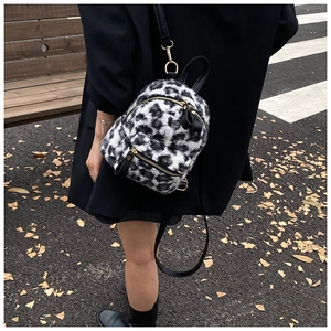 Outdoor street view of a mini leopard print backpack with soft faux fur texture