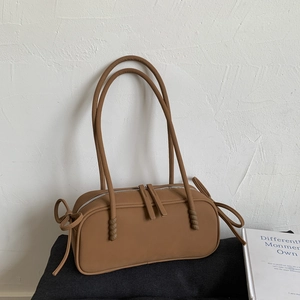 Detail of matte leather texture and double zipper on caramel brown shoulder bag