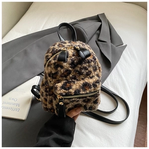Close-up of fluffy leopard print mini backpack with golden zipper and black straps