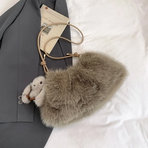 Détail du sac seau en peluche taupe avec bandoulière en cuir et charm lapin