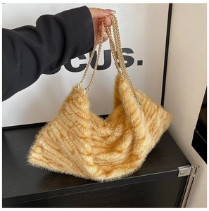 Détail du cabas en fausse fourrure tigre avec bandoulières en chaîne dorée et texture douce