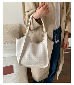 Dettaglio della trama in pelle intrecciata bianca su una borsa hobo oversize minimal