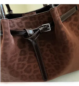 Detail of leopard print suede tote with dark brown leather strap and silver metal buckle