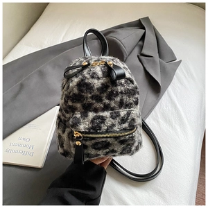 Detailed view of plush leopard print mini backpack with golden zippers and leather straps