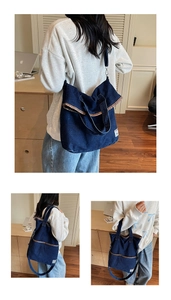 Detail of blue denim tote bag with brown leather trim and dual strap versatile design