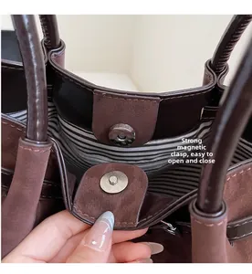 Detail view of the brown tote bag featuring a strong magnetic snap button closure