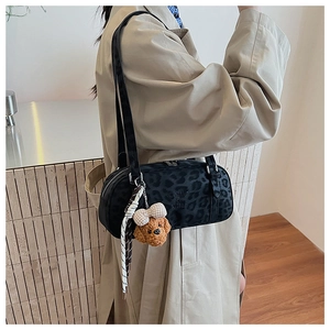 Detail view of leopard print shoulder bag with teddy bear charm and brand logo
