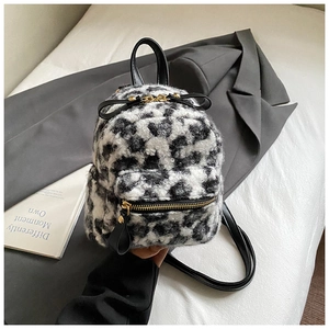 Detail view of mini leopard print plush backpack with black bow and golden metal zipper