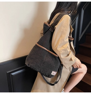 Detail of black washed denim tote bag with brown leather piping on indoor stairs corner