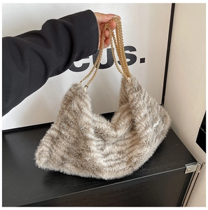 Détail d'un sac cabas en fausse fourrure léopard avec anses en chaîne dorée et peluche