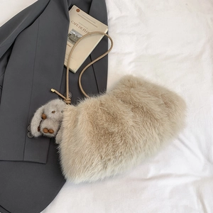Gros plan sur le sac seau en fausse fourrure beige avec pendentif lapin mignon