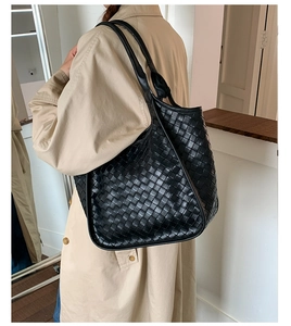 Dettaglio della borsa tote in pelle nera intrecciata che mostra la trama artigianale fine