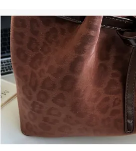 Close-up of leopard print suede tote bag with leather drawstring in office setting