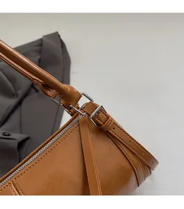 Detail of silver hardware and adjustable leather strap on brown vintage shoulder bag