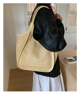 Vista dettagliata della borsa tote intrecciata beige con motivo Intrecciato a spalla