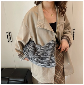 Sac cabas chic en peluche léopard avec chaîne dorée porté à l'épaule par un mannequin