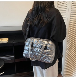 Sac fourre-tout argenté matelassé sur modèle montrant la texture et la bandoulière