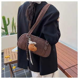 Detailed back view of a brown suede shoulder bag with leopard pattern and bear charm