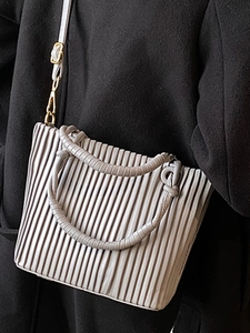 French style pleated bucket bag in light grey with gold hardware for a chic shoulder look