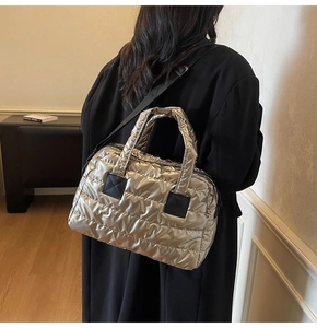 Détail du sac fourre-tout matelassé doré avec fixations de bandoulière noires