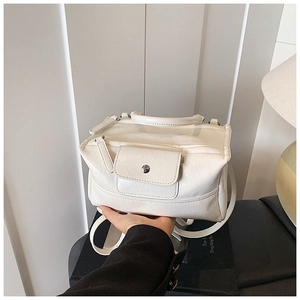 Close-up of white lychee texture leather bag with metal clasp and stitch details