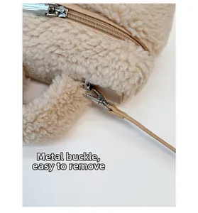 Dettaglio borsa di peluche beige con cerniera in metallo argento e fibbia rimovibile