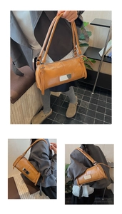 Detailed macro view of yellow-brown leather cylinder bag with silver metal plate
