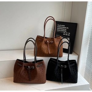 Detailed view of three leopard print tote bags in caramel, dark brown and black finishes