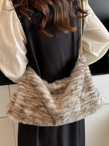 Sac fourre-tout tendance en peluche léopard avec chaîne dorée porté par un mannequin
