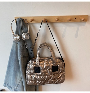 Détail du sac cabas matelassé doré champagne avec texture bouffante et sangle noire