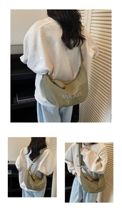 Detail view of avocado green crescent crossbody bag with MULAIDI logo and mini pouch