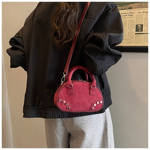Detail view of burgundy frosted crossbody bag with silver studs and adjustable strap